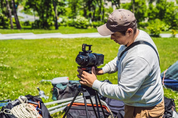 Um cameraman profissional prepara uma câmera e um tripé antes de atirar — Fotografia de Stock