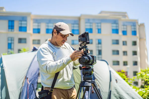 Çekimden önce bir kamera ve bir tripod bir profesyonel kameraman hazırlar — Stok fotoğraf