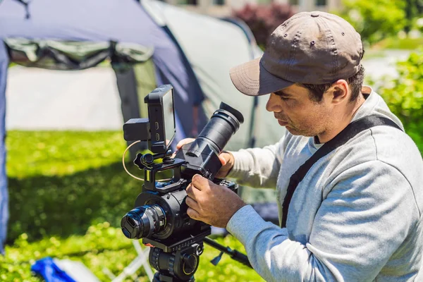 Çekimden önce bir kamera ve bir tripod bir profesyonel kameraman hazırlar — Stok fotoğraf