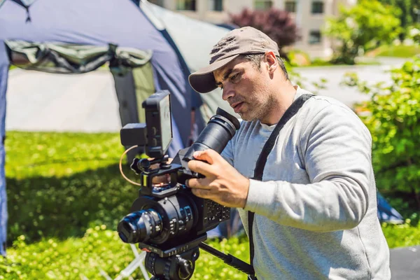 Un operatore professionista prepara una macchina fotografica e un treppiede prima di scattare — Foto Stock