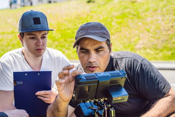 Un operatore cameraman discutere il processo di ripresa con un regista e dp — Foto Stock