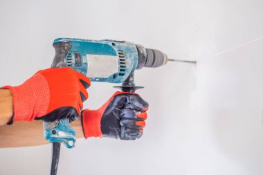 Erkek Close-up yapım hole beton duvar ile profesyonel matkap eller..