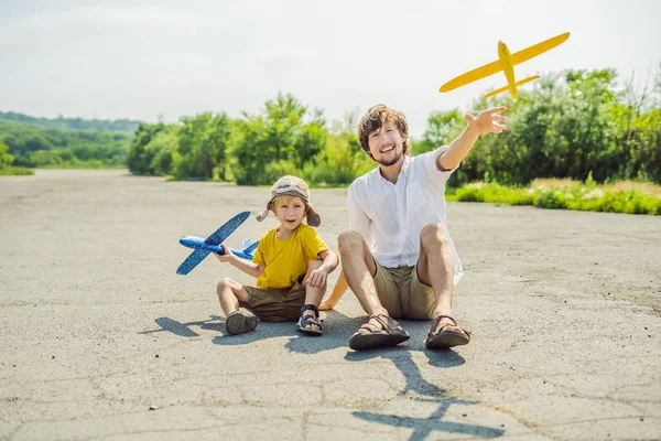 Buon padre e figlio che giocano con l'aeroplano giocattolo sullo sfondo della vecchia pista. Viaggiare con il concetto di bambini — Foto Stock