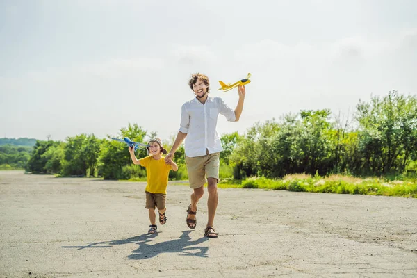 Ευτυχής πατέρας και γιος παίζει με αεροπλάνο παιχνίδι φόντο παλιά διάδρομο. Ταξιδεύοντας με παιδιά — Φωτογραφία Αρχείου