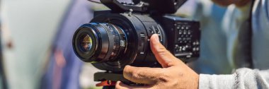 Afiş, uzun biçimde çekimden önce bir kamera ve bir tripod bir profesyonel kameraman hazırlar