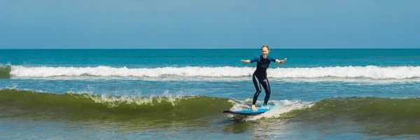 Giovane donna allegra surfista principiante con il surf blu si diverte sulle piccole onde del mare. Stile di vita attivo in famiglia, persone lezioni di sport acquatici all'aperto e attività di nuoto nel campo da surf vacanza estiva BANNER, LONG — Foto Stock