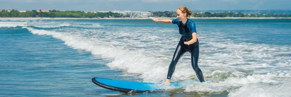Joyful young woman beginner surfer with blue surf has fun on small sea waves. Active family lifestyle, people outdoor water sport lesson and swimming activity on surf camp summer vacation BANNER, LONG — Stock Photo, Image