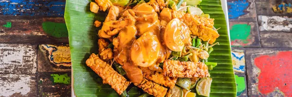 Salad Gado-gado Indonesia disajikan dengan saus kacang. Bahan: tahu, bayam, buncis, kedelai, kentang, mentimun dan telur rebus BANNER, LONG FORMAT — Stok Foto