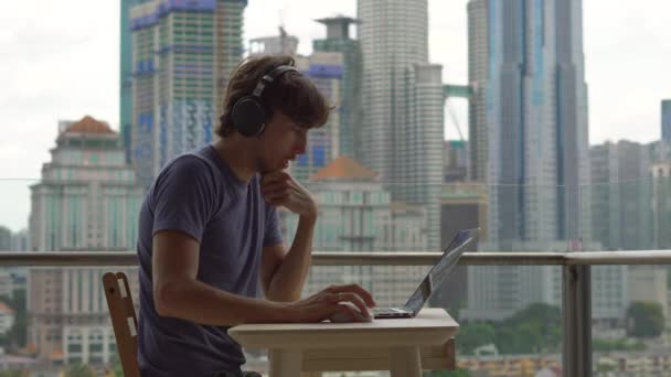 年轻的男性自由职业者思考 而在阳台上工作的城市中心背景 — 图库视频影像