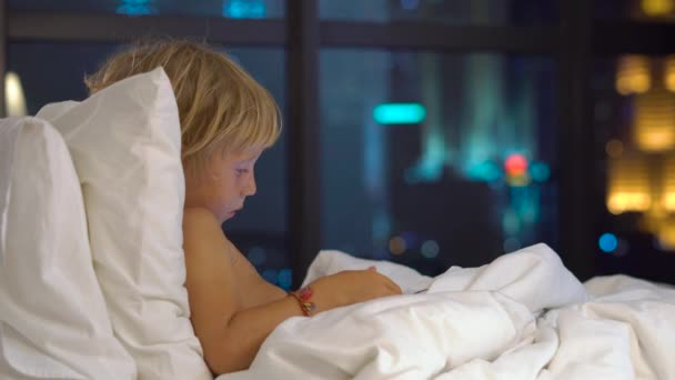 Pequeño Niño Rubio Sentado Cama Por Noche Jugando Tableta Digital — Vídeo de stock