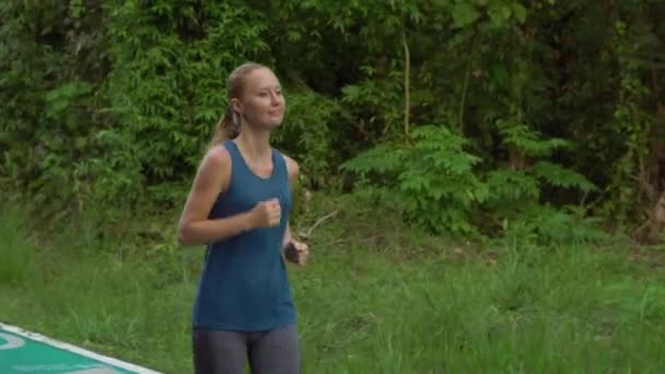 Steadicam scatto di una giovane donna che corre in un parco tropicale — Video Stock