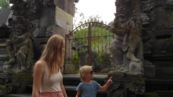 若い女性とインドネシア バリ島ウブドのプラ グヌン Lebah 寺院を歩いての幼い息子のスローモーション — ストック動画
