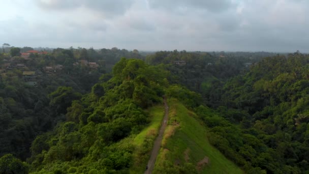 インドネシア バリ島ウブド村に霧の空の下でアーティスト歩く Campuhan リッジの航空写真 — ストック動画