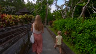 Genç bir kadın ve küçük oğlu Bali Adası'Taman Ayun Kraliyet Sarayı ziyaret Slowmotion steadicam atış