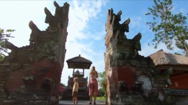 Genç bir kadın ve küçük oğlu Bali Adası'Taman Ayun Kraliyet Sarayı ziyaret Slowmotion steadicam atış.