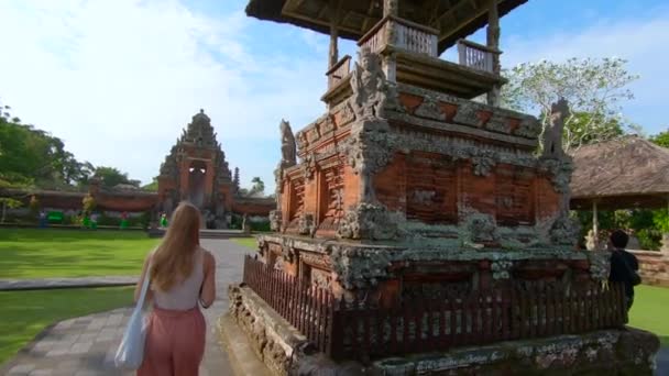Slowmotion steadicam disparo de una joven mujer y su pequeño hijo visitando el palacio real Taman Ayun en la isla de Bali — Vídeo de stock