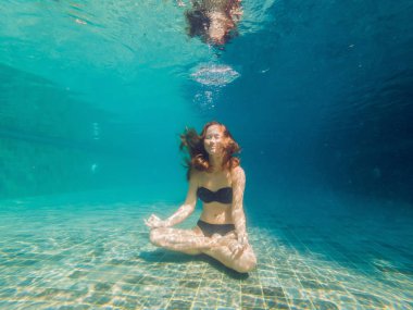 Genç kadın siyah Bikini yoga konumda sualtı dalış akvaryum, tam vücut shot, önden görünüm