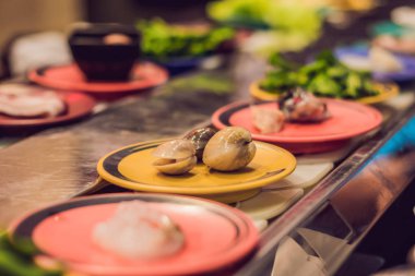 Bir kafede tabaklarda çiğ gıda ile bir konveyör