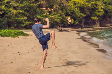 Kumsalda, sportif adam egzersizleri yapıyor çalışma dışarı genç erkek
