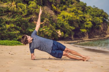 Kumsalda, sportif adam egzersizleri yapıyor çalışma dışarı genç erkek