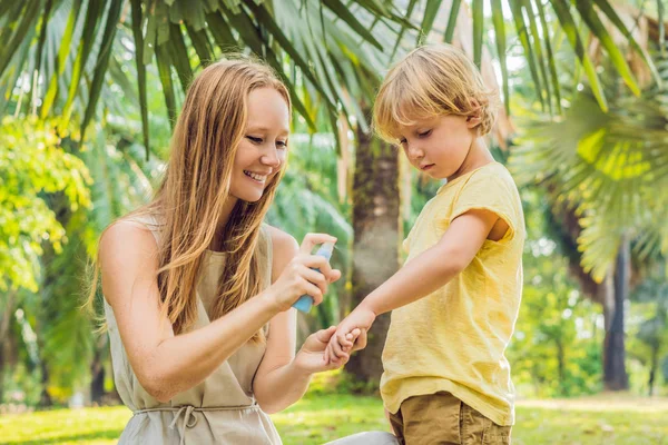Mom and son use mosquito spray.Spraying insect repellent on skin outdoor — Stock Photo, Image