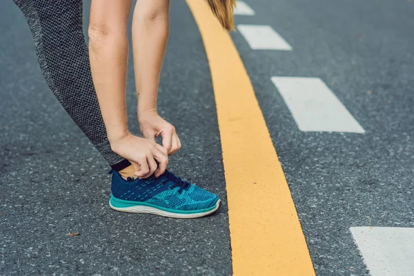 Corredor femenino atándose los zapatos preparándose para trotar fuera. Corredor joven girld preparándose para el entrenamiento. Estilo de vida deportivo — Foto de Stock