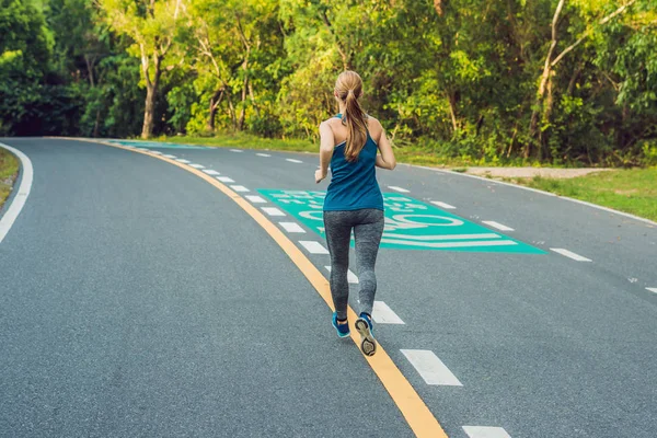 Спортивная женщина, бегающая по дороге на рассвете. Фитнес и тренировки — стоковое фото