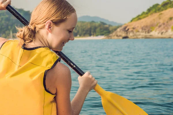 Una giovane donna sorridente che fa kayak in mare. Giovane donna felice in canoa in mare in una giornata estiva — Foto Stock