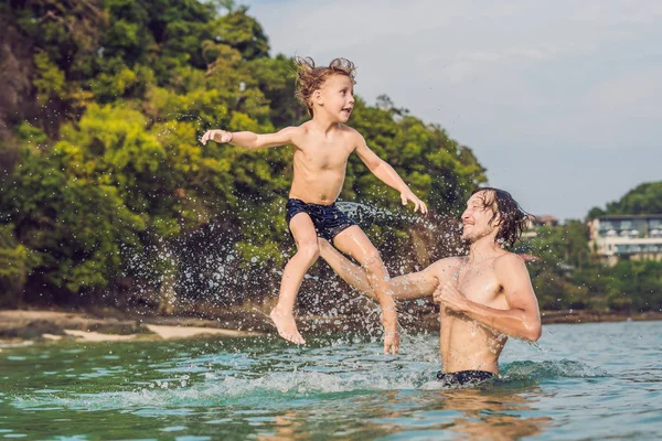 Padre e figlio che giocano sulla spiaggia durante il giorno — Foto Stock