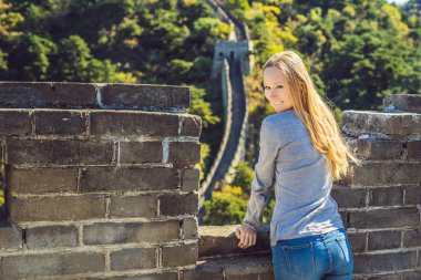 Happy cheerful joyful tourist woman at Great Wall of China having fun on travel smiling laughing and dancing during vacation trip in Asia. Girl visiting and sightseeing Chinese destination clipart