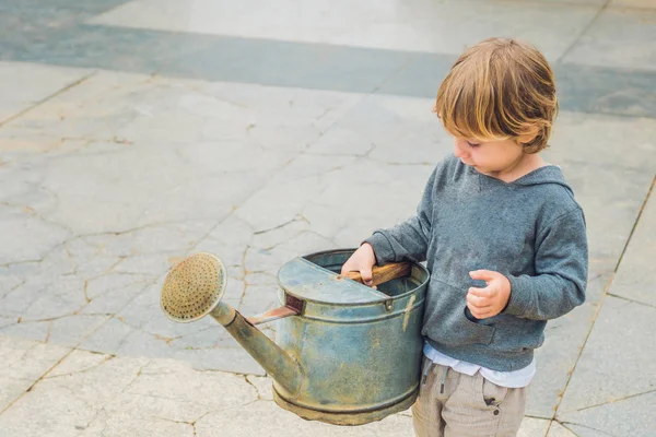 Cute little boy watering flowers watering can — Stock Photo, Image