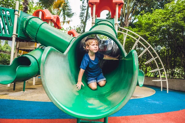 Renkli çocuk parkında oynayan küçük mutlu çocuk. Sevimli çocuk dışarıda eğleniyor. — Stok fotoğraf