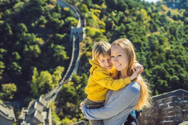 Happy cheerful joyful tourists mom and son at Great Wall of China having fun on travel smiling laughing and dancing during vacation trip in Asia. Chinese destination. Travel with children in China