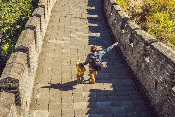 Felices turistas alegres alegres papá e hijo en la Gran Muralla de China divirtiéndose en viajes sonriendo y bailando durante el viaje de vacaciones en Asia. Destino chino. Viajar con niños en China — Foto de Stock