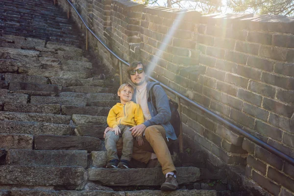 Gelukkig vrolijke vrolijke toeristen vader en zoon op de grote muur van China op plezier reizen glimlachen, lachen en dansen tijdens de vakantiereis in Azië. Chinese bestemming. Reizen met kinderen in China — Stockfoto