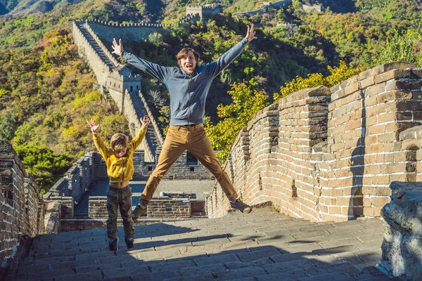 Gelukkig vrolijke vrolijke toeristen vader en zoon op de grote muur van China op plezier reizen glimlachen, lachen en dansen tijdens de vakantiereis in Azië. Chinese bestemming. Reizen met kinderen in China — Stockfoto