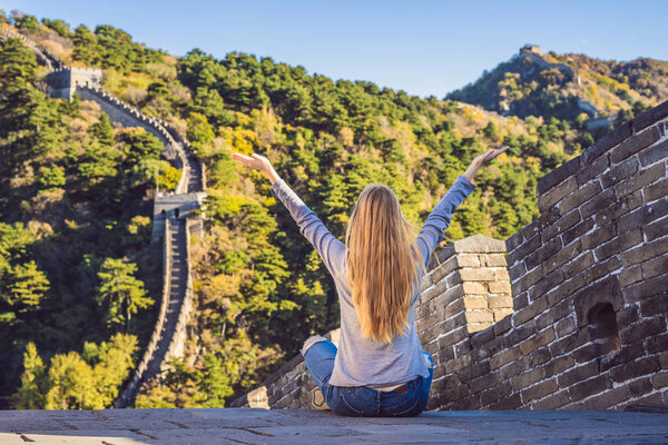 Happy cheerful joyful tourist woman at Great Wall of China having fun on travel smiling laughing and dancing during vacation trip in Asia. Girl visiting and sightseeing Chinese destination
