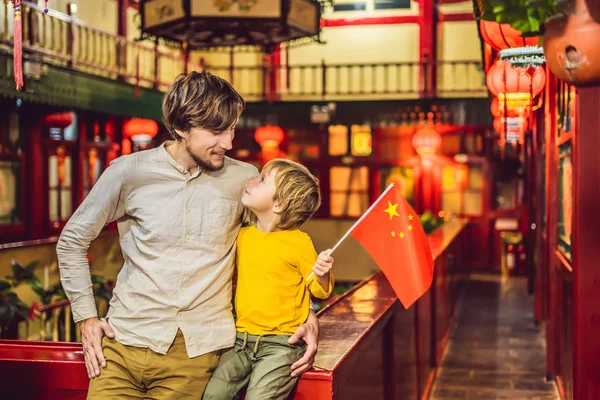 Απολαμβάνουν διακοπές στην Κίνα. Ευτυχισμένος τουρίστες μπαμπάς και γιος με μια κινεζική σημαία σε κινέζικα φόντο. Ταξίδι στην Κίνα, με την έννοια τα παιδιά. Θεώρηση ελεύθερης διαμετακόμισης 72 ώρες, 144 ώρες στην Κίνα — Φωτογραφία Αρχείου