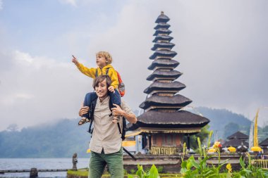 Baba ve oğul Pura Ulun Danu Bratan, Bali arka planda. Hindu Tapınağı çiçek Bratan Gölü, Bali çevrili. Shivaite su Tapınağı Bali, Endonezya Binbaşı. Hindu Tapınağı. Birlikte yolculuk