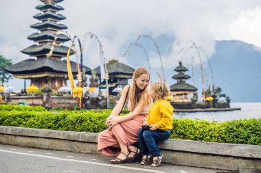 Anne ve oğlu Pura Ulun Danu Bratan, Bali arka planda. Hindu Tapınağı çiçek Bratan Gölü, Bali çevrili. Shivaite su Tapınağı Bali, Endonezya Binbaşı. Hindu Tapınağı. Birlikte yolculuk