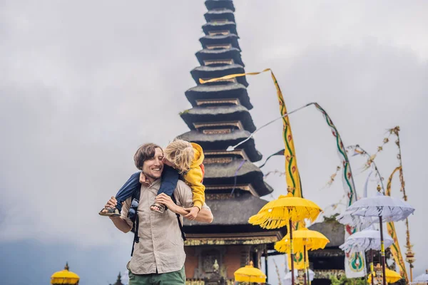 Papá e hijo en el fondo de Pura Ulun Danu Bratan, Bali. Templo hindú rodeado de flores en el lago Bratan, Bali. Mayor templo de agua Shivaite en Bali, Indonesia. Templo hindú. Viajar con — Foto de Stock