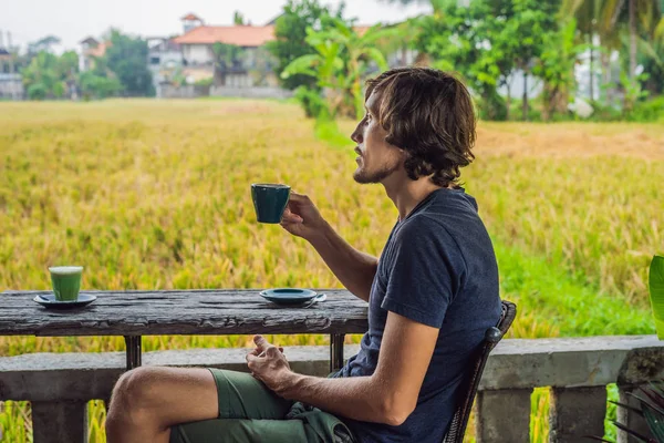 Mann mit einer Tasse Kaffee auf der Café-Veranda in der Nähe der Reisterrassen auf Bali, Indonesien — Stockfoto