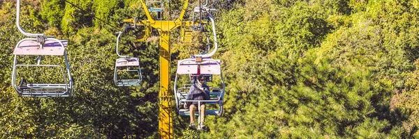 A man rides the cable car to the Great Wall of China BANNER, LONG FORMAT