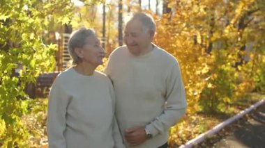 Sarılma ve birbirlerine güzel bir parkta bir sonbahar ortam gülümseyen yaşlı bir çift doz Slowmotion