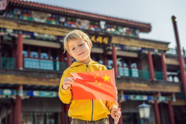 Tatil Çin'de zevk. Eski Çin Caddesi'nin arka plan Ulusal Çin bayrağını genç çocuk. Çin kavramı için seyahat. Vize ücretsiz transit 72 saat, Çin'deki 144 saat