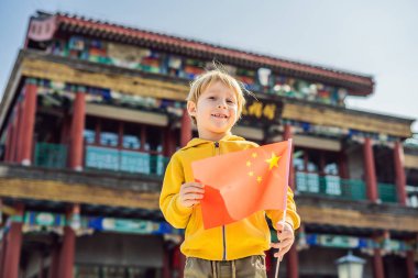 Tatil Çin'de zevk. Eski Çin Caddesi'nin arka plan Ulusal Çin bayrağını genç çocuk. Çin kavramı için seyahat. Vize ücretsiz transit 72 saat, Çin'deki 144 saat