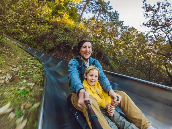 Dad and son have fun on alpine roller coaster