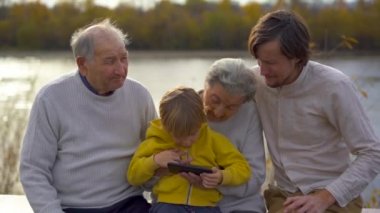 Grandgrandson babası ile birlikte kadeh Slowmotion grandgrand ailesi onun cep telefonu uygulamaları kullanmayı öğretmek.
