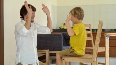 Baba ve oğul ahşap mobilya küçük parçalar bir araya getirin. Adam ve çocuk birbirlerine beş sandalye bitirdikten sonra araya vermek.