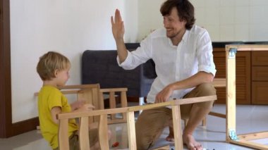 Baba ve oğul ahşap mobilya küçük parçalar bir araya getirin. Adam ve çocuk birbirlerine beş sandalye bitirdikten sonra araya vermek.